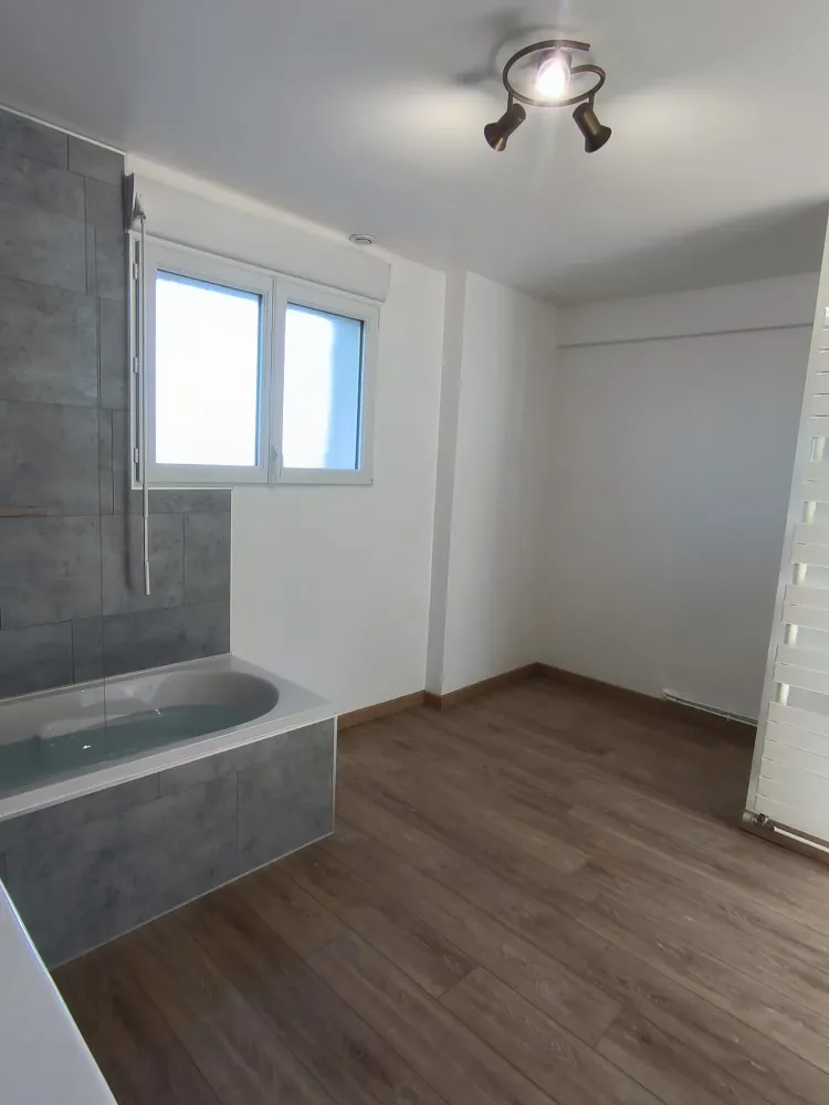 Baignoire grise dans une grande salle de bains